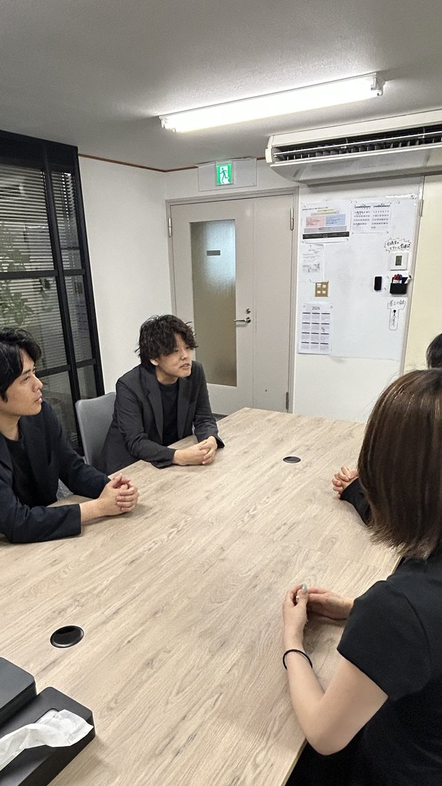 会議室で意見を交わすメンバー