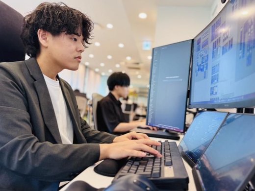 デスクで作業するメンバー